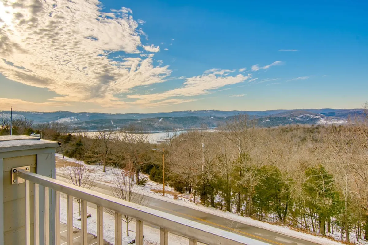 A breathtaking view of the lake with distant hills and captivating cloud formations visible. The natural scenery provides a sense of tranquility and showcases the outdoor environment surrounding the property.
